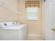 Well-equipped laundry room with washer, dryer, window, and shelving for convenience at 1607 Tail Feather Dr, Kissimmee, FL 34746