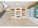 Inviting living room featuring custom built-ins, a ceiling fan, and access to the staircase at 1607 Tail Feather Dr, Kissimmee, FL 34746