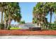 Oaks National Golf Club sign surrounded by palm trees and red mulch at 1607 Tail Feather Dr, Kissimmee, FL 34746