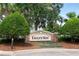 Stone sign for Eagle's Nest community entrance, showcasing mature trees and meticulous landscaping at 1607 Tail Feather Dr, Kissimmee, FL 34746