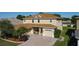 A well-maintained two-story home, showcasing a brick paver driveway, landscaping, and a three-car garage at 1915 Acacia Dr, Kissimmee, FL 34758