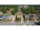 Aerial shot showcases the home, manicured lawn, and neighborhood with mature trees at 1915 Acacia Dr, Kissimmee, FL 34758