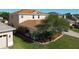A view of a well-manicured backyard and landscaped side yard. The house is two stories with a brown roof at 1915 Acacia Dr, Kissimmee, FL 34758