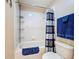 Bathroom shows a tub with shower, a white tiled walls, and towel rack; simple and bright at 1915 Acacia Dr, Kissimmee, FL 34758