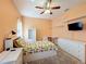 Bright bedroom with ceiling fan, desk, storage, and comfortable pineapple-themed bedding at 1915 Acacia Dr, Kissimmee, FL 34758
