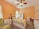 Cozy bedroom with natural light, ceiling fan, pineapple-themed bedding, and built-in shelving at 1915 Acacia Dr, Kissimmee, FL 34758
