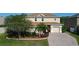 A beautiful two-story home featuring lush landscaping, a well-manicured lawn, and a brick paver driveway at 1915 Acacia Dr, Kissimmee, FL 34758