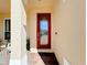 A beautifully designed front door with glass panes, set in a beige facade, is framed by brick pavers at 1915 Acacia Dr, Kissimmee, FL 34758