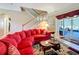 Comfortable living room featuring tile floors, a staircase, sliding doors to the screened lanai and a red sofa at 1915 Acacia Dr, Kissimmee, FL 34758