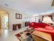 Spacious living room with tile floors, a red sofa, and open doorway into another room at 1915 Acacia Dr, Kissimmee, FL 34758