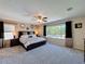 Spacious main bedroom featuring a large window, neutral walls, ceiling fan, and plush carpet at 1915 Acacia Dr, Kissimmee, FL 34758