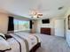 Bright main bedroom featuring a large window, ceiling fan, plush carpet, and mounted television at 1915 Acacia Dr, Kissimmee, FL 34758