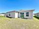 Exterior backyard view featuring a well-maintained lawn and a covered patio area at 219 Summerlin Loop, Haines City, FL 33844