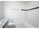Clean bathroom with modern fixtures, a tub and shower combo, and sleek granite counters providing an elegant aesthetic at 219 Summerlin Loop, Haines City, FL 33844