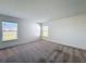 Well-lit bedroom showcasing neutral carpet and two windows with scenic views at 219 Summerlin Loop, Haines City, FL 33844
