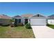 Charming single-story home featuring a two-car garage and well-maintained front yard landscaping at 219 Summerlin Loop, Haines City, FL 33844