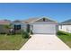 Charming single-Gathering home featuring a two-car garage, well-maintained lawn, and inviting curb appeal at 219 Summerlin Loop, Haines City, FL 33844