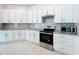 Modern kitchen featuring white cabinetry, stainless steel appliances, subway tile backsplash and granite countertops at 219 Summerlin Loop, Haines City, FL 33844