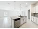 Open kitchen island with a sink, modern appliances, and seamless flow to the dining area at 219 Summerlin Loop, Haines City, FL 33844