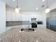 Bright kitchen featuring white cabinets, stainless steel appliances and a granite topped island with sink at 219 Summerlin Loop, Haines City, FL 33844
