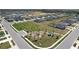 Wide aerial view of a park in a housing development, with playground and green spaces at 219 Summerlin Loop, Haines City, FL 33844