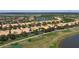 Aerial view of community of yellow homes near golf course and lakes at 2502 Palm Tree Dr, Poinciana, FL 34759