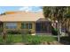 Backyard featuring a screen enclosed lanai and green lawn and gardens at 2502 Palm Tree Dr, Poinciana, FL 34759