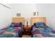 Bedroom with two beds, a nightstand, and colorful quilted bedspreads at 2502 Palm Tree Dr, Poinciana, FL 34759
