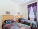 Bright bedroom with two beds and colorful quilted bedspreads at 2502 Palm Tree Dr, Poinciana, FL 34759