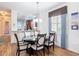 Dining area with hardwood floors, a long table, modern seating, and a view into the spacious kitchen at 2502 Palm Tree Dr, Poinciana, FL 34759
