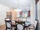 Dining area featuring modern chairs, a table runner, and a view into the well-equipped kitchen at 2502 Palm Tree Dr, Poinciana, FL 34759