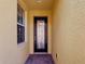 Front entry door with side window on yellow home at 2502 Palm Tree Dr, Poinciana, FL 34759