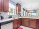 Kitchen featuring custom wood cabinets, stone countertops, stainless steel appliances, and a window over the sink at 2502 Palm Tree Dr, Poinciana, FL 34759