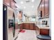 A spacious kitchen with stainless steel appliances, wooden cabinets, and tile flooring for modern convenience at 2502 Palm Tree Dr, Poinciana, FL 34759
