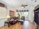 Inviting living room featuring a comfortable leather sofa, ceiling fan, and sliding glass doors to the patio at 2502 Palm Tree Dr, Poinciana, FL 34759