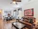 Cozy living area showcasing a leather sofa, hardwood floors, and an adjacent dining space filled with natural light at 2502 Palm Tree Dr, Poinciana, FL 34759