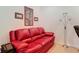 Living room with red sofa, floor lamp, and framed pictures on the wall at 2502 Palm Tree Dr, Poinciana, FL 34759