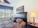 Relaxing bedroom with tray ceiling featuring a king-size bed, bedside tables, and a bright window view at 2502 Palm Tree Dr, Poinciana, FL 34759