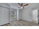 Well-lit bedroom with ceiling fan, window with blinds, hardwood flooring, and closet at 2801 Palmyra Ct, St Cloud, FL 34772