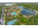 Drone shot of a community with a pool, tennis courts and a pond surrounded by trees at 2835 Oakwater Dr # 2835, Kissimmee, FL 34747