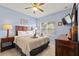 Cozy bedroom features a ceiling fan, wooden furniture, and a decorative headboard at 2835 Oakwater Dr # 2835, Kissimmee, FL 34747