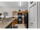 Functional kitchen featuring oak cabinetry and modern black appliances and tile flooring at 2835 Oakwater Dr # 2835, Kissimmee, FL 34747