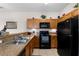 Functional kitchen featuring oak cabinetry and modern black appliances and tile flooring at 2835 Oakwater Dr # 2835, Kissimmee, FL 34747