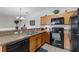 Functional kitchen featuring oak cabinetry and modern black appliances and tile flooring at 2835 Oakwater Dr # 2835, Kissimmee, FL 34747