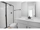 Modern bathroom features a sleek shower with a glass door, white cabinets, and ample counter space at 2943 Gavin Sky Dr, Kissimmee, FL 34744