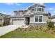 Charming two-story home featuring gray siding, stone accents, and a well-manicured front yard at 2943 Gavin Sky Dr, Kissimmee, FL 34744