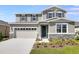 Charming two-story home featuring gray siding, stone accents, and a well-manicured front yard at 2943 Gavin Sky Dr, Kissimmee, FL 34744