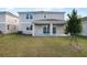 Back exterior of home showing a covered patio and grassy yard space at 2961 Gavin Sky Dr, Kissimmee, FL 34744