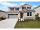 Inviting two-story home with a two-car garage, stone accents, and red shutters at 2961 Gavin Sky Dr, Kissimmee, FL 34744