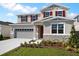 Inviting two-story home with a two-car garage, stone accents, and red shutters at 2961 Gavin Sky Dr, Kissimmee, FL 34744